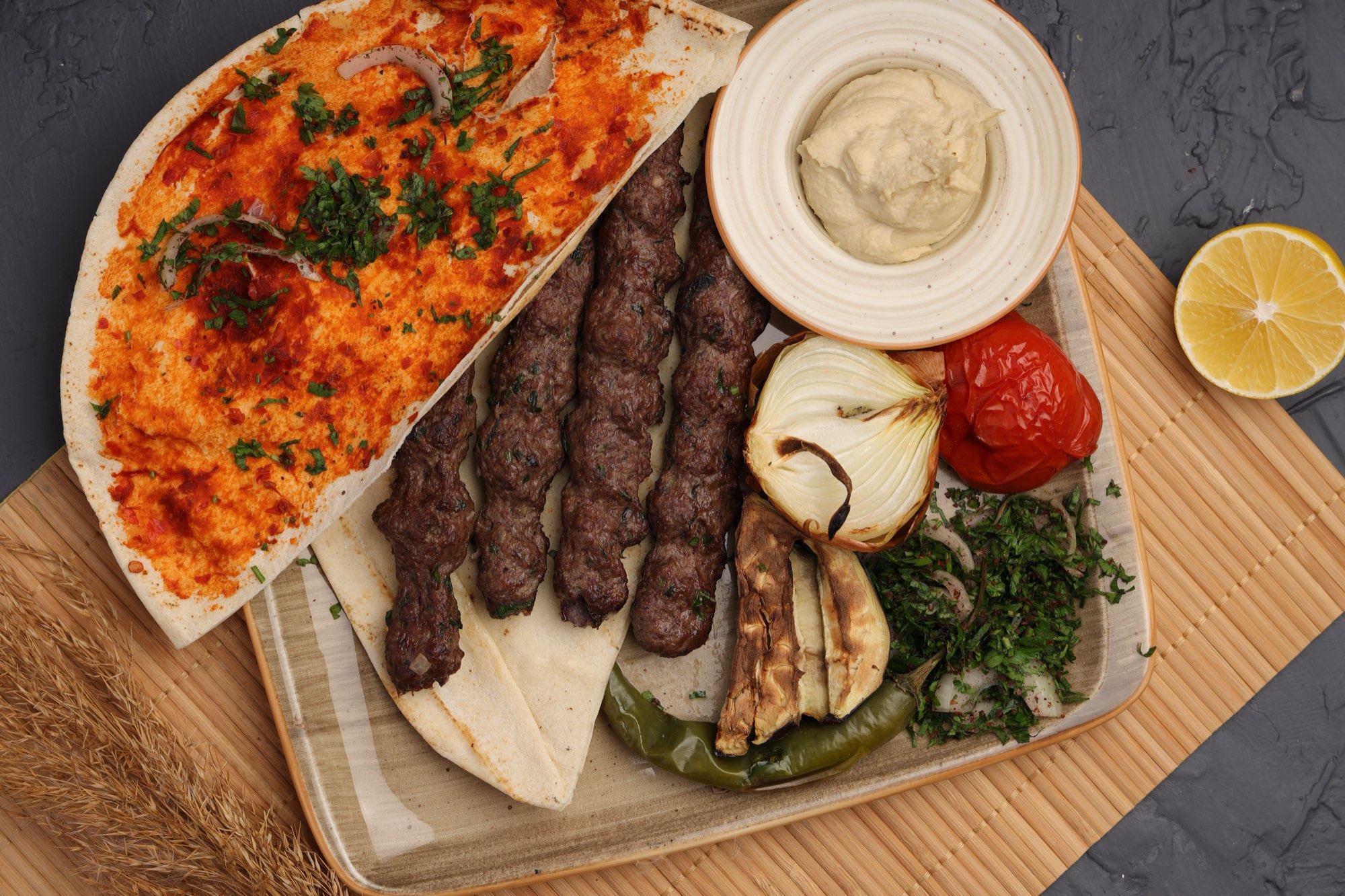 Iraqi kebab skewers with grilled vegetables, hummus and bread